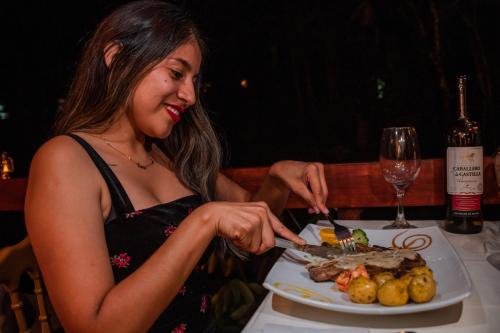 a woman sitting at a table with a plate of food at Amazon Puyu Glamping in Tarqui