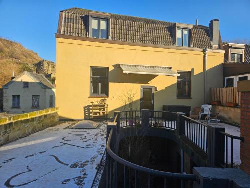 ein großes gelbes Gebäude mit einer Terrasse davor in der Unterkunft Bed & Breakfast Serendipity in Valkenburg