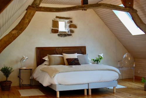 a bedroom with a large bed in a attic at Cottage de charme & jardin fabuleux à 800m de la mer - Maison Melchior in Flamanville