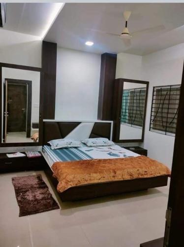 - une chambre avec un lit et deux miroirs dans l'établissement Abhinandan guesthouse, à Gondia