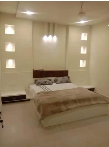 - une chambre avec un grand lit et 2 fenêtres dans l'établissement Abhinandan guesthouse, à Gondia