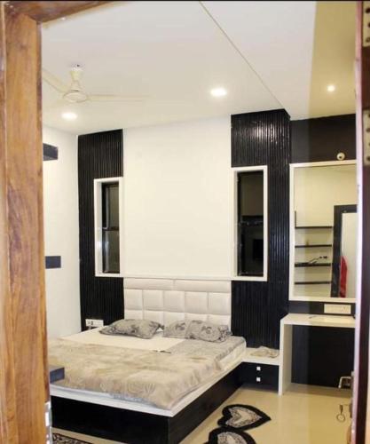 - une chambre avec un lit et un grand miroir dans l'établissement Abhinandan guesthouse, à Gondia
