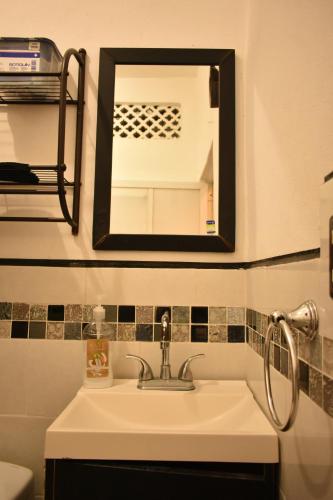 W łazience znajduje się umywalka i lustro. w obiekcie Casa Aragón Ortiz w mieście Santa Cruz Huatulco