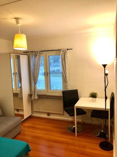 sala de estar con escritorio, mesa y 2 ventanas en Charming Studio in kista en Estocolmo