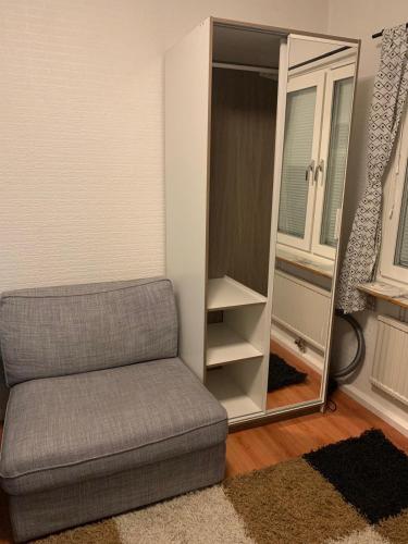 uma sala de estar com um sofá e um espelho em Charming Studio in kista em Estocolmo