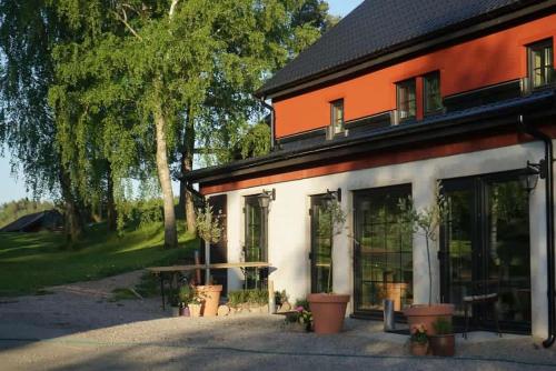 um edifício laranja e branco com vasos de plantas em frente em Boutiquehotell Dahlbogården em Alingsås