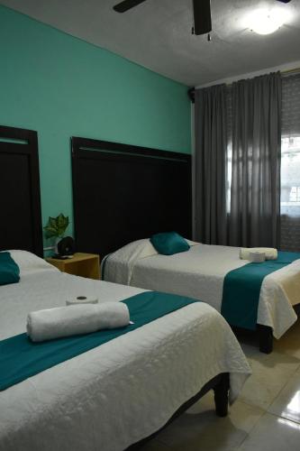 pokój hotelowy z 2 łóżkami i niebieskimi ścianami w obiekcie Casa Aragón Ortiz w mieście Santa Cruz Huatulco