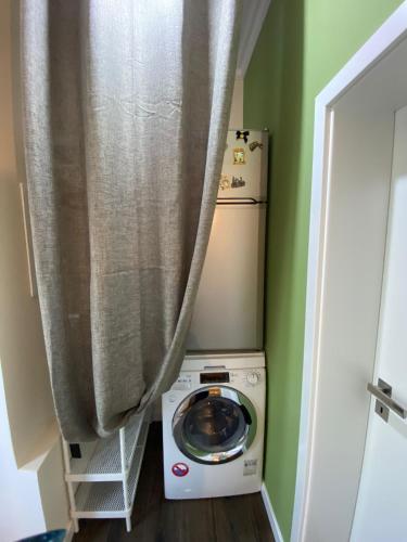 a washer and dryer in a room with a curtain at Apartment im Hinterhof in Bersenbrück