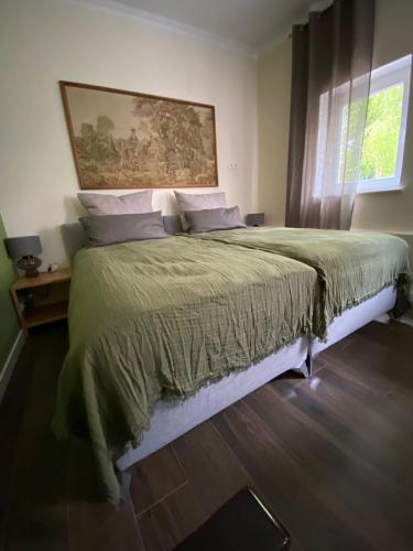 a bedroom with a large bed with a painting on the wall at Apartment im Hinterhof in Bersenbrück