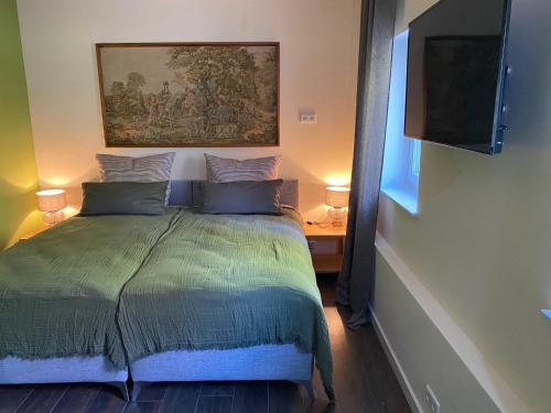 a bedroom with a bed with a tv on the wall at Apartment im Hinterhof in Bersenbrück