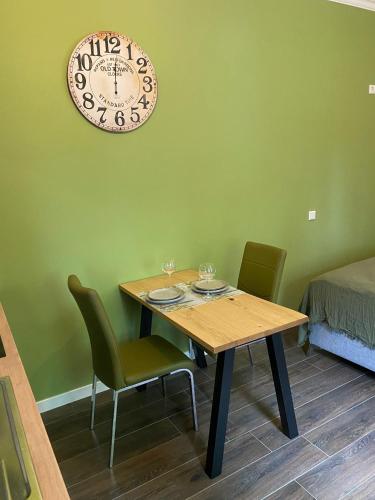 a dining room table with chairs and a clock on the wall at Apartment im Hinterhof in Bersenbrück