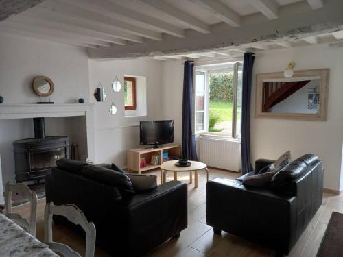 - un salon avec deux canapés en cuir et une cheminée dans l'établissement Holiday home in the heart of the Swiss normandy, à Le Vey