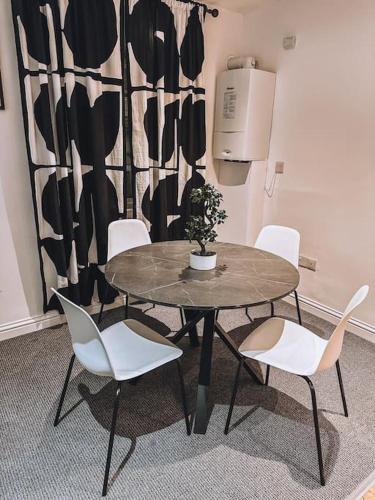 une table et des chaises avec une plante en pot dans l'établissement Modern 2 bedroom Flat in Balham, à Londres