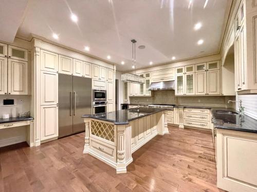 una grande cucina con armadi bianchi e un piano di lavoro nero di Vihome520-Beautiful house near North York Center a Toronto