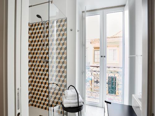 a bathroom with a shower with a glass door at Casa Apollo Guesthouse in Faro