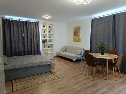 ein Schlafzimmer mit einem Bett, einem Tisch und einem Sofa in der Unterkunft BELLEVUE in Narva