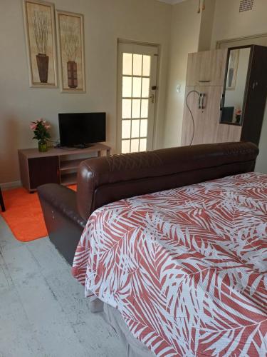 a bedroom with a bed and a television at 5 On Cologne in Germiston