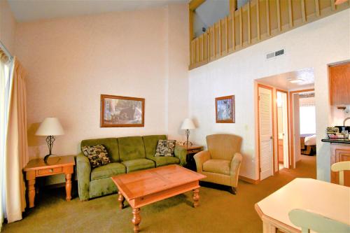 a living room with a green couch and a chair at Lagonita Lodge in Big Bear Lake