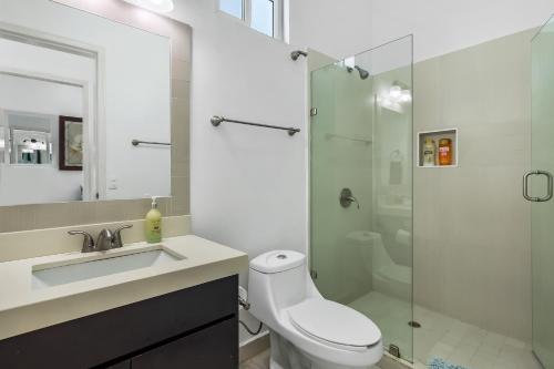 een badkamer met een toilet, een wastafel en een douche bij Villa Turquesa 56 - Playa Arcangel in Rosarito