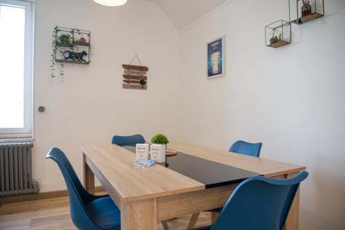 a dining room with a wooden table and blue chairs at La Belle Rive du voyageur in Bellerive-sur-Allier