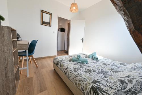 a bedroom with a bed and a desk and a chair at La Belle Rive du voyageur in Bellerive-sur-Allier