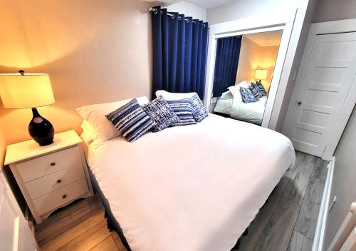 Dormitorio pequeño con cama y espejo en Beautiful Guesthouse, Sleeps 4 - Kitchen, Private Laundry, AC, Parking, 65' TV, Close to Stores, Restaurants & Beach en Long Beach