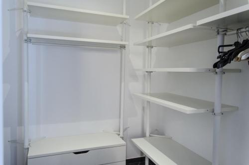a white closet with white shelves in it at Maria Vittoria Charming Rooms and Apartments in Brindisi