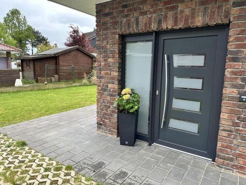 a black door with a potted plant on a brick house at Fewo am Tillysee in Wardenburg in Wardenburg