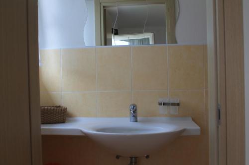 a bathroom with a sink and a mirror at Appartamenti Vacanza Il Riale in Cannobio