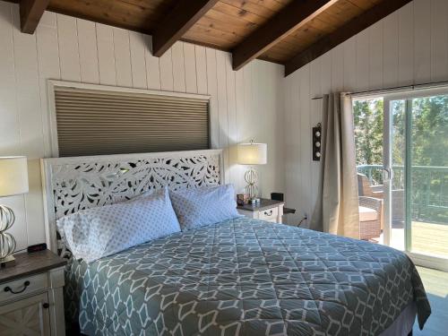 a bedroom with a large bed with blue pillows at Lakeview Ridge+ lake view + Balcony’s + Game Room in Lake Arrowhead
