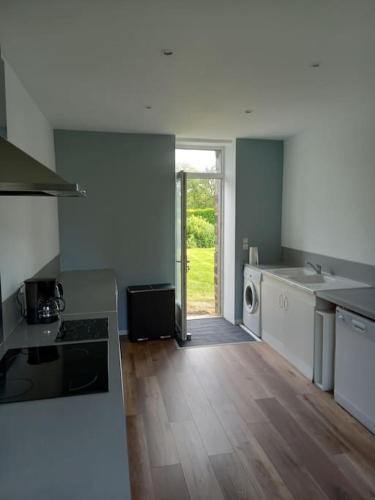 une cuisine vide avec une porte ouverte sur une cour dans l'établissement Holiday home in the Normandy countryside, à La Villette