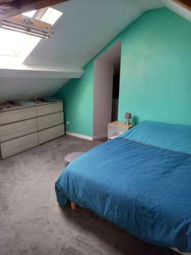 - une chambre avec un lit bleu et un mur vert dans l'établissement Holiday home in the Normandy countryside, à La Villette