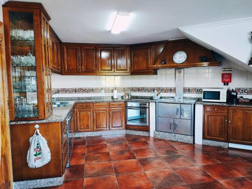 una cucina con armadi in legno e pavimento piastrellato di Varanda do Outeiro a Melgaço