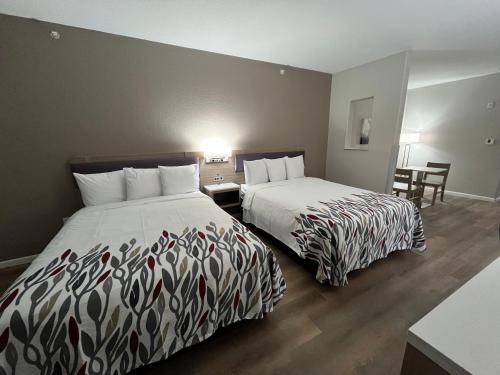 two beds sitting next to each other in a hotel room at Red Roof PLUS San Antonio Northeast in San Antonio