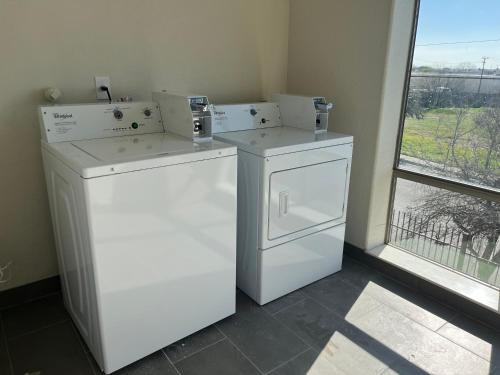 2 lavadoras y secadora en una habitación con ventana en Red Roof PLUS San Antonio Northeast, en San Antonio