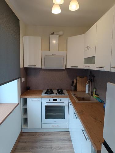 a kitchen with white cabinets and a stove top oven at BELLEVUE in Narva