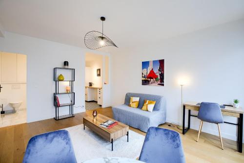 un salon avec un canapé bleu et une table dans l'établissement Élégance Parisienne au cœur du Marais, à Paris