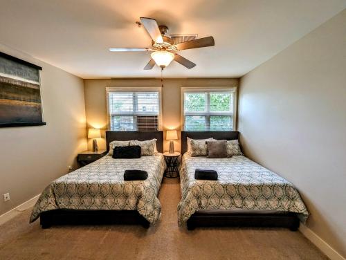 a bedroom with two beds and a ceiling fan at Cashville - Stylish Condo Minutes from Broadway in Nashville