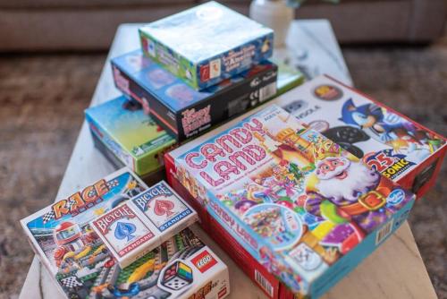 a pile of childrens games on a table at Light Bright Stylish PRIVATE Home - Whitworth in Spokane