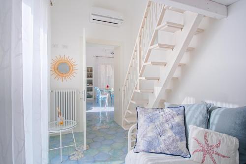 ein Wohnzimmer mit einer Treppe und einer Couch in der Unterkunft Devalù casa del mare in Cefalú