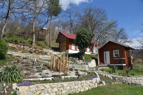 een huis met een stenen muur en een tuin bij Kuca za odmor Lola in Ivanjica