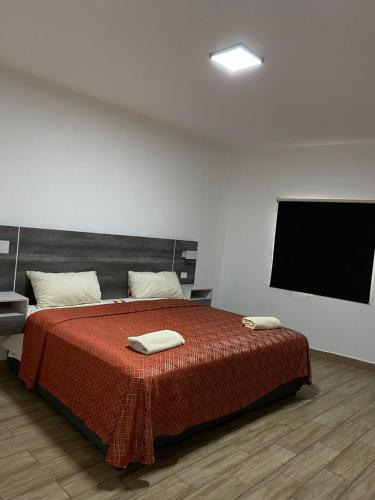 a bedroom with a bed and a flat screen tv at Hotel Sevilla Paraíso in Paraíso