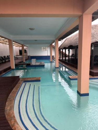 a swimming pool with blue water in a building at Grandview adventure and guesthouse in East London