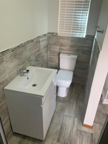 a bathroom with a white sink and a toilet at Grandview adventure and guesthouse in East London