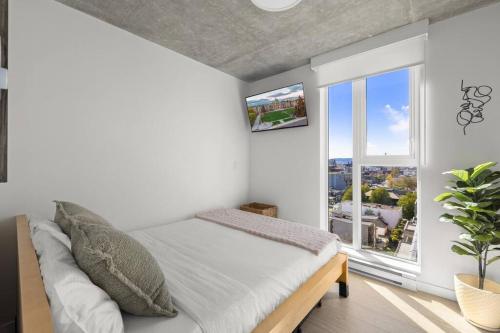 Un dormitorio con una cama y una ventana grande. en Majestic Views at The Mod, en Victoria