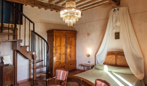 1 dormitorio con cama y lámpara de araña en Agriturismo Il Palazzino en Bibbona