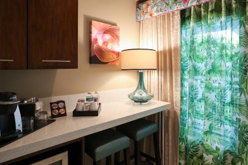 a hotel room with a table with a lamp and stools at Orchid Key Inn - Adults Only in Key West