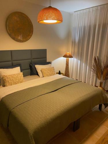 a bedroom with a large bed and a lamp at Villa CD30 with private heated pool in Caleta De Fuste