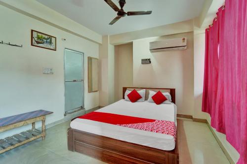 a bedroom with a bed and a red curtain at OYO Flagship Hotel CDS Regency in Patna
