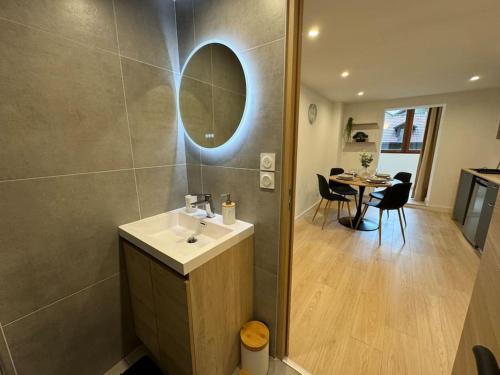 een badkamer met een wastafel, een spiegel en een tafel bij Destination Royale in Annecy